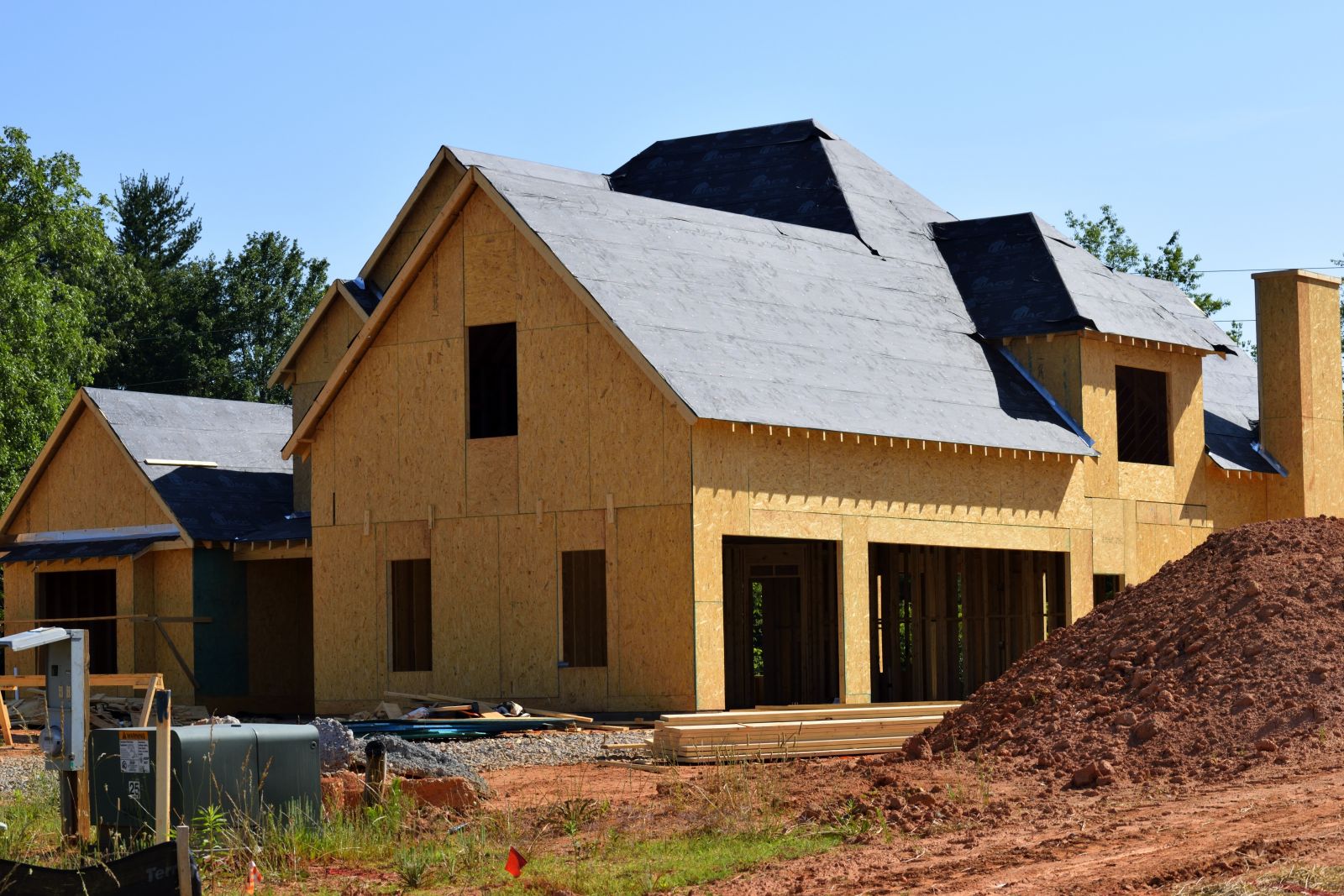 Home under construction with roofing being worked on.
