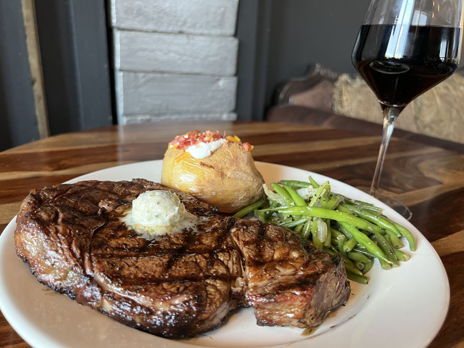 steak with a side of green beans and a baked potato