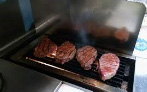 Four steaks on the grill