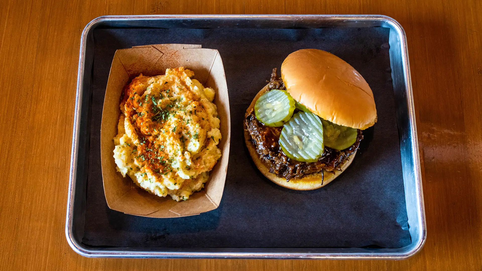 BBQ sandwich with side of potatoes